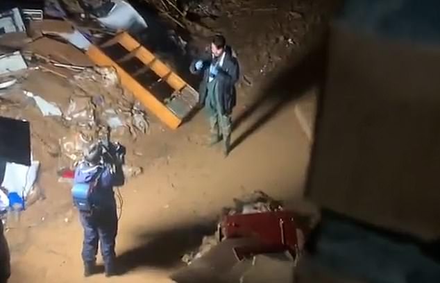 Shocking moment ‘shameful’ Spanish influencer is caught deliberately kneeling down to cover himself in mud in Valencia’s flood-ravaged streets moments before filming a report