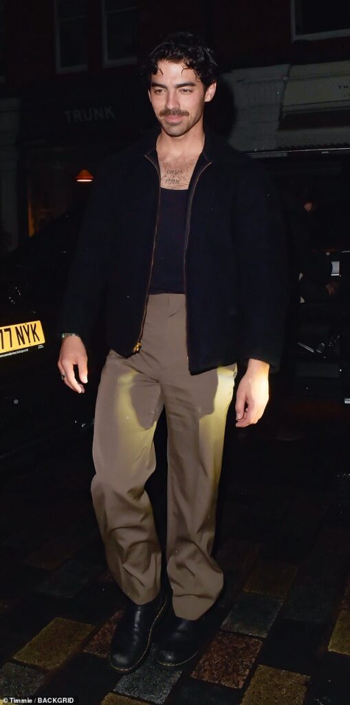 Joe Jonas shows off his chest tattoo in low-cut T-shirt and bomber jacket during a night out in London