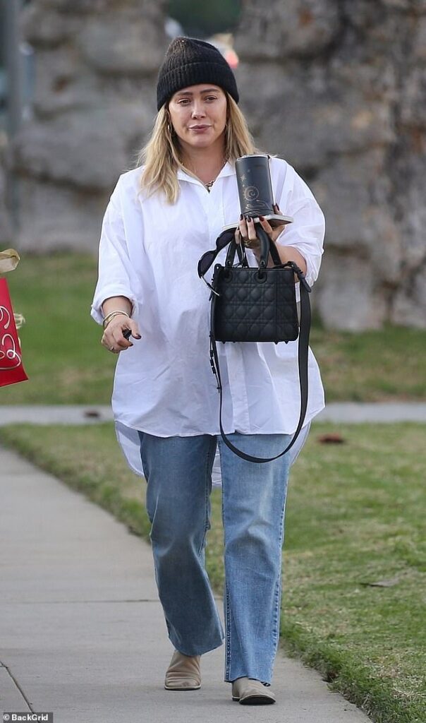 Pregnant Hilary Duff covers her belly in a white button-up shirt and dons a black beanie as she’s seen with son Luca, 11, in LA
