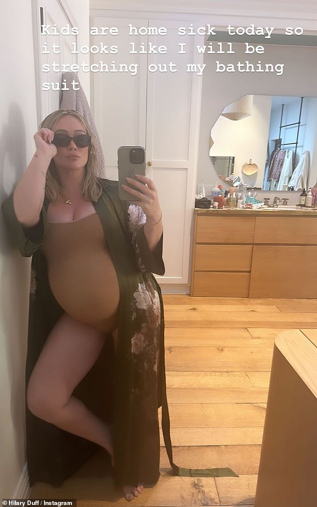 Pregnant Hilary Duff, 36, proudly showcases her growing baby bump in a bathing suit and floral robe while posing for stylish selfie