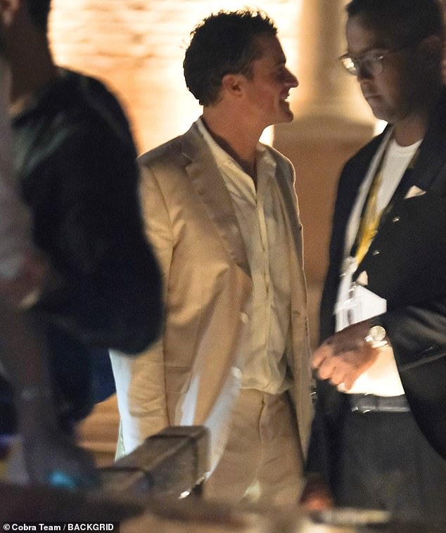 The pictures that will break Katy Perry’s heart: Playboy Orlando Bloom caught wrapping arm around mystery woman after Bezos’ wedding party washout