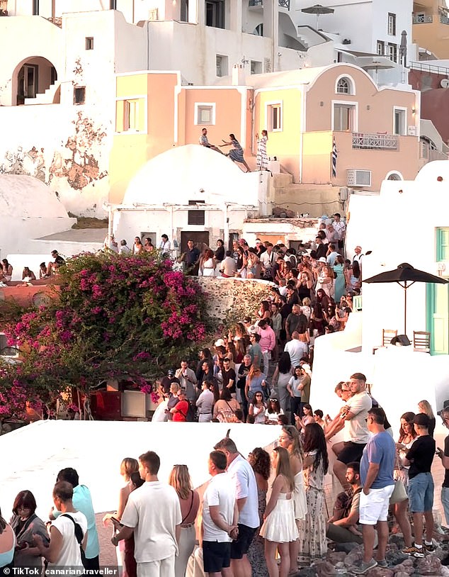 The tourist invasion of ‘Instagram island’: Thousands of selfie-hunting holidaymakers pack the narrow streets of Santorini to capture sunset view loved by influencers