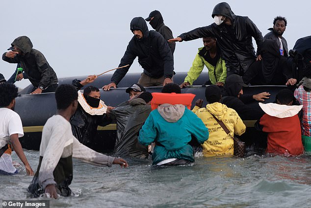 Chaos on French shores as ‘people trafficker’ is seen WHIPPING terrified migrants as they scramble to board boat bound for the UK