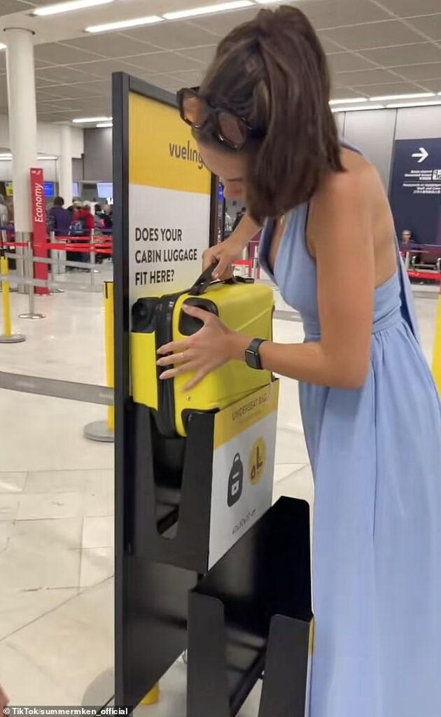 ‘Never give up!’: Moment determined passenger hammers her cabin luggage into airport bag size checker to avoid £180 charge on flight to London