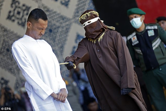 Two gay men grimace in pain as they are brutally whipped in public Sharia caning over their same-sex relations in Indonesian province of Aceh