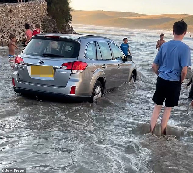 Panic as Brit tourists get stuck in sea after visitors park on sand at popular UK beach